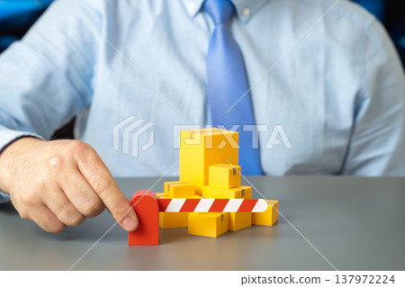 A closed barrier and boxes of goods. Restrictions on imports and transit closures. Trade wars and tariffs disrupt supply chains while limiting market access and increasing business risks. A closed barrier and boxes of goods. Restrictions on imports and transit closures. Trade wars and tariffs disrupt supply chains while limiting market access and increasing business risks. 137972224