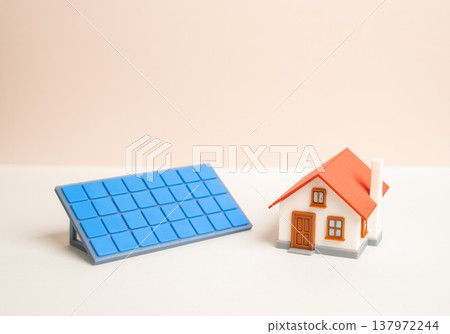A house and a solar panel. Home autonomy with renewable energy systems. Sustainable living reduces dependence on grid electricity while increasing property value and environmental responsibility. A house and a solar panel. Home autonomy with renewable energy systems. Sustainable living reduces dependence on grid electricity while increasing property value and environmental responsibility. 137972244