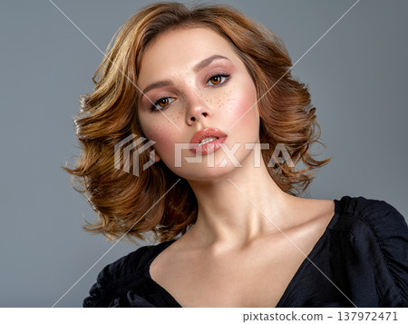 Beautiful brown haired with stylish short hairstyle. Woman with a  curly hair. Beautiful young woman with freckles on face.  Closeup portrait of an attractive girl  with a brown makeup. 137972471