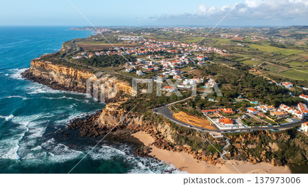 Aerial view of a small European town against blue sky and Atlantic Ocean. Drone view of a beautiful European city with a hilly landscape with ocean . Top view - Beautiful natural beauty. Portugal. 137973006