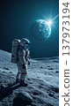 An astronaut in a space suit stands on the lunar surface, gazing at Earth in the distance. The scene is illuminated by a bright star. 137973194