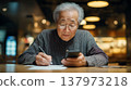 Image of a senior citizen using a smartphone 137973218