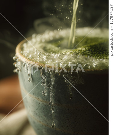 Macro Water Drop Falling onto Dark Reflective Surface with Ripples 137974157