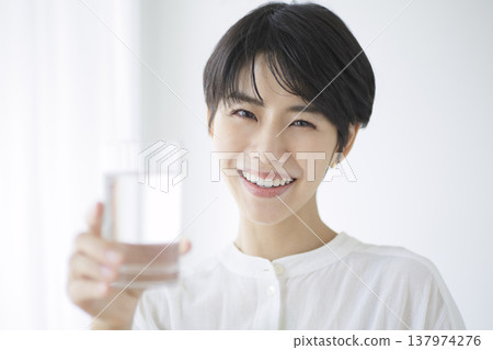 一位年輕女子過著她的日常生活：補充水分，崇尚自然的生活方式。 137974276