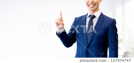 A male businessman pointing his index finger to guide you A male businessman pointing his index finger to guide you 137974747