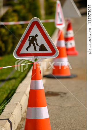 Roadworks warning sign with orange traffic cones Roadworks warning sign with orange traffic cones 137975055