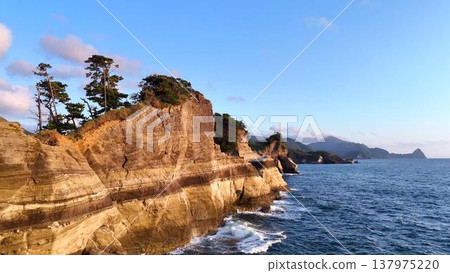 The coastline of Dogashima. White cliffs and sheer rock formations stand out against the evening sky (aerial view, West Izu). 137975220