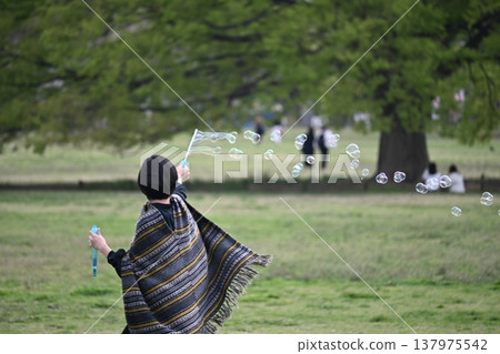Women playing with soap bubbles Women playing with soap bubbles 137975542