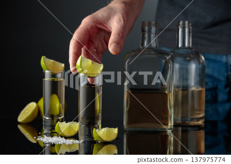 Gold tequila with sea salt and lime slices. Gold tequila with sea salt and lime slices. 137975774
