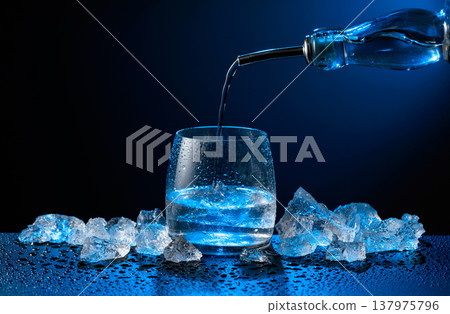 Vodka pours from bottle to glass. Vodka pours from bottle to glass. 137975796