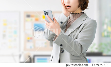 一位女士/女商人對自己的智慧型手機感到驚訝 137975992