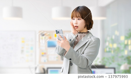 一位女士/女商人對自己的智慧型手機感到驚訝 137975993