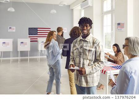 Happy young African American man is standing in queue at election station in USA 137976204