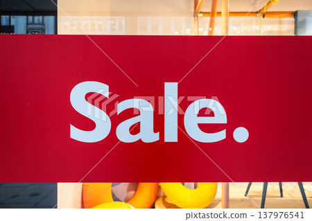 Red sale sign displayed on a retail store window Red sale sign displayed on a retail store window 137976541