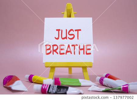 Just Breathe symbol. Wooden blocks with words Just Breathe. Beautiful pink background with paints and easel. Business and Just Breathe concept. Copy space. Just Breathe symbol. Wooden blocks with words Just Breathe. Beautiful pink background with paints and easel. Business and Just Breathe concept. Copy space. 137977002
