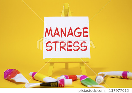 Manage stress symbol. Concept word Manage stress on wooden blocks. Beautiful yellow background with paints and easel. Business and Manage stress concept. Copy space 137977013