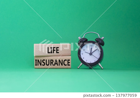 Life insurance symbol. Concept word Life insurance on wooden blocks. Beautiful green background with alarm clock. Business and Life insurance concept. Copy space Life insurance symbol. Concept word Life insurance on wooden blocks. Beautiful green background with alarm clock. Business and Life insurance concept. Copy space 137977059
