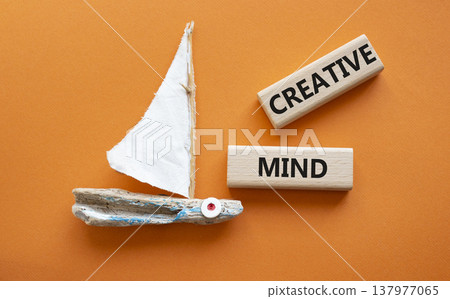 CREATIVE MIND symbol. Concept word CREATIVE MIND on wooden blocks. Beautiful orange background with boat. Business and CREATIVE MIND concept. Copy space 137977065