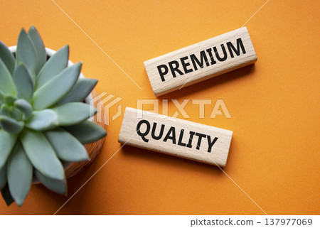 PREMIUM QUALITY symbol. Concept word PREMIUM QUALITY on wooden blocks. Beautiful orange background with succulent plant. Business and PREMIUM QUALITY concept. Copy space 137977069