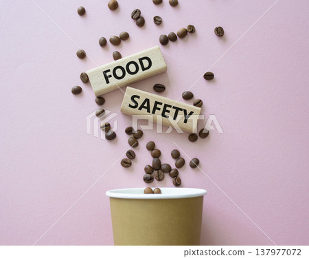 Food Safety symbol. Concept words Food Safety on beautiful wooden picture frame. Beautiful pink background with coffee cup and coffee beans. Business and Food Safety concept. Copy space. Food Safety symbol. Concept words Food Safety on beautiful wooden picture frame. Beautiful pink background with coffee cup and coffee beans. Business and Food Safety concept. Copy space. 137977072