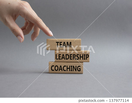 Team leadership coaching symbol. Concept word Team leadership coaching on wooden blocks. Businessman hand. Beautiful grey background. Business and Team leadership coaching. Copy space Team leadership coaching symbol. Concept word Team leadership coaching on wooden blocks. Businessman hand. Beautiful grey background. Business and Team leadership coaching. Copy space 137977114