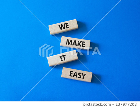 We Make it Easy symbol. Concept words We Make it Easy on wooden blocks. Beautiful bright blue background. Business and We Make it Easy concept. Copy space. 137977208