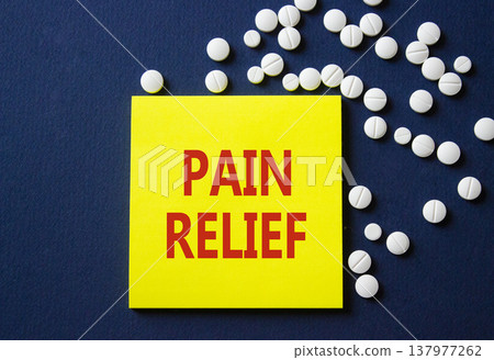 Pain Relief symbol. Concept word Pain Relief on yellow note. Beautiful deep blue background with pills. Medicine and Pain Relief concept. Copy space Pain Relief symbol. Concept word Pain Relief on yellow note. Beautiful deep blue background with pills. Medicine and Pain Relief concept. Copy space 137977262
