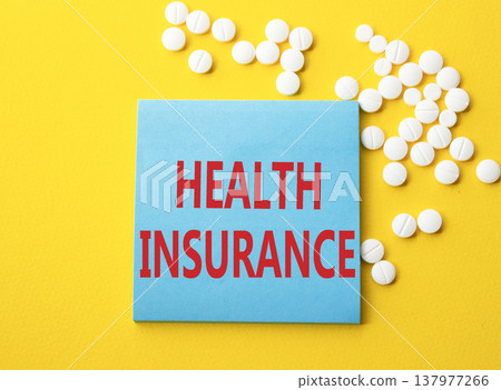 Health Insurance symbol. Concept word Health Insurance on blue note. Beautiful yellow background with pills. Medicine and Health Insurance concept. Copy space 137977266