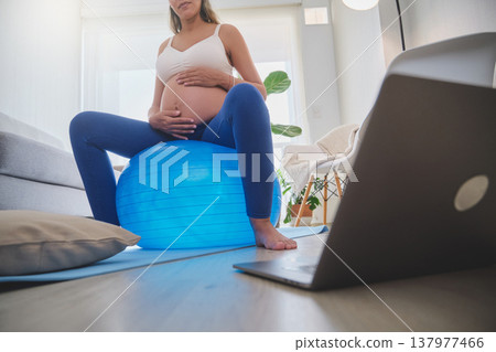 Pregnant woman exercising with a fitness ball at home 137977466