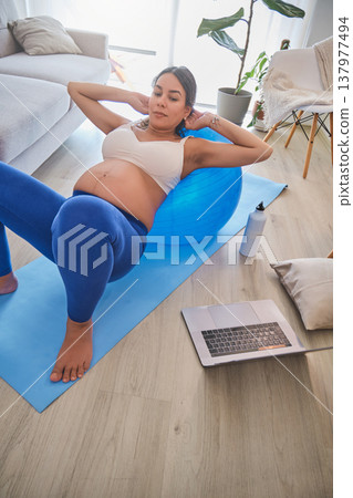 Pregnant woman exercising with fitness ball at home 137977494
