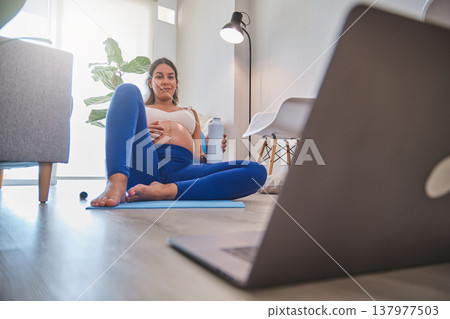 Pregnant woman exercising at home for prenatal fitness wellness Pregnant woman exercising at home for prenatal fitness wellness 137977503