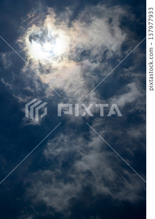 The sun shining in the blue sky and rainbow-colored clouds 137977933