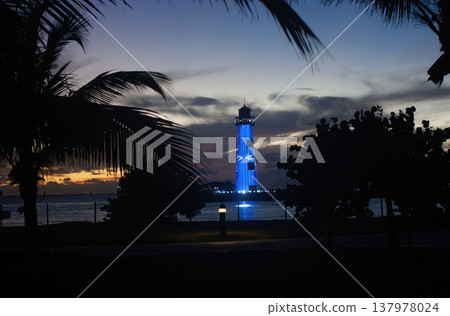 Lighthouse illuminated in blue at sunset amidst the vegetation of the island of Bahamas. Travel destinations Tropical beach. Wallpaper 137978024