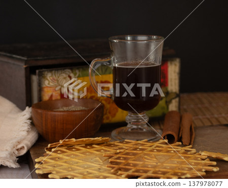 Delicious crunchy cinnamon biscuits with coffe. Dark background Delicious crunchy cinnamon biscuits with coffe. Dark background 137978077