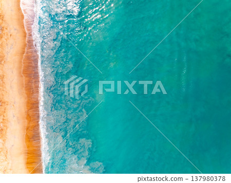 Top view waves crashing on beach background Top view waves crashing on beach background 137980378