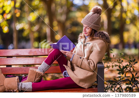 Woman with anorexia writing in diary during autumn park visit Woman with anorexia writing in diary during autumn park visit 137980589