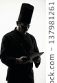 Black silhouette of chef in toque carefully studying menu or recipe. 137981261