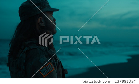 Silhouette of a soldier saluting America Memorial Day on a nighttime beach 137981354