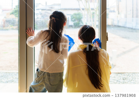 A girl and her mother wiping the floor. A girl and her mother wiping the floor. 137981908