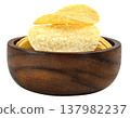 Delicious crispy potato chips presented in a dark round wooden bowl. Savory snack food perfect for parties and appetizers. High quality close up studio food photography. 137982237