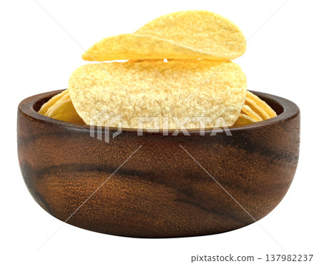 Delicious crispy potato chips presented in a dark round wooden bowl. Savory snack food perfect for parties and appetizers. High quality close up studio food photography. 137982237