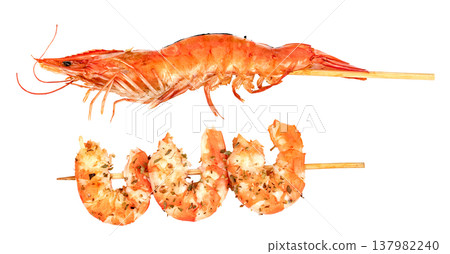 Two grilled shrimp skewers isolated. One skewer features a whole large prawn, while the other holds peeled seasoned shrimp tails. Fresh seafood concept for food photography. Two grilled shrimp skewers isolated. One skewer features a whole large prawn, while the other holds peeled seasoned shrimp tails. Fresh seafood concept for food photography. 137982240