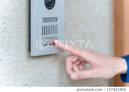 The hand of the person pressing the intercom 137982968