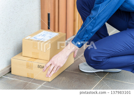 送貨司機將包裹放在前門。 137983101