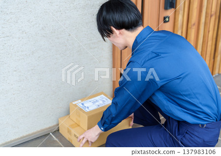 Delivery driver leaves package at the front door. 137983106