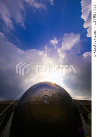 The silver dome of the Fukui Prefectural Dinosaur Museum, shining in the backlight, against a dramatic sky. The silver dome of the Fukui Prefectural Dinosaur Museum, shining in the backlight, against a dramatic sky. 137983419