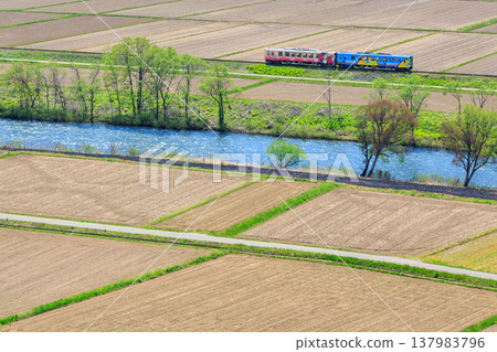 一列由里高原鐵道的柴油車組沿著小吉川行駛，穿過等待春天到來的田野。 137983796