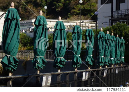 橫須賀港海軍基地遊覽出發點和到達點的折疊式遮陽傘。 橫須賀港海軍基地遊覽出發點和到達點的折疊式遮陽傘。 137984231