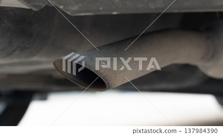 High angle and close up of a vehicle's dual exhaust tailpipes. Featuring a polished chrome finish. Showcases the sleek metallic design and the clean integration into the car's rear bumper. High angle and close up of a vehicle's dual exhaust tailpipes. Featuring a polished chrome finish. Showcases the sleek metallic design and the clean integration into the car's rear bumper. 137984390