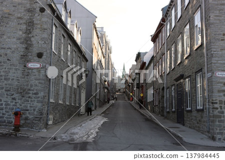 A streetscape of stone buildings stretching straight through the old town of Quebec in winter. A streetscape of stone buildings stretching straight through the old town of Quebec in winter. 137984445